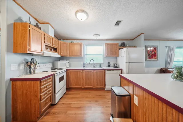 a kitchen with granite countertop a refrigerator and a sink