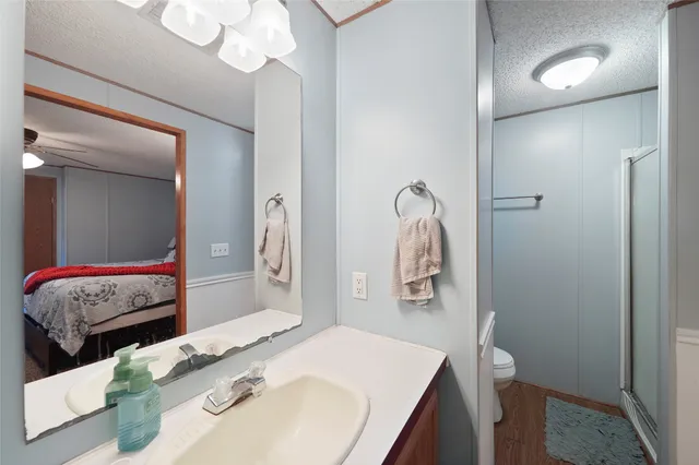 a en suite bathroom with a granite countertop sink and a mirror