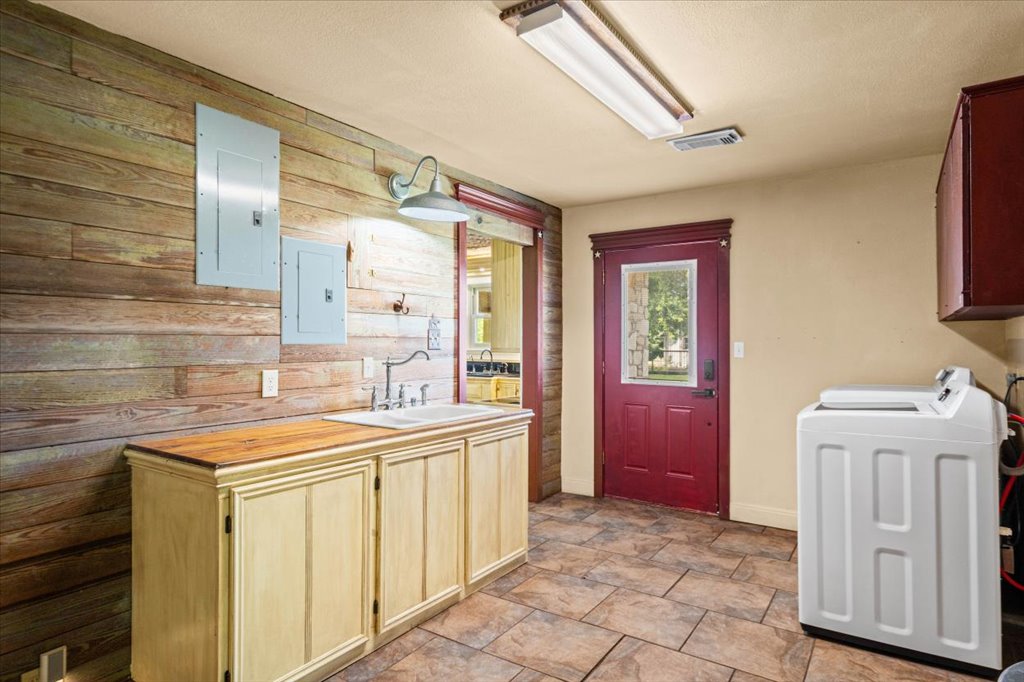 2421 Post Oak Road Webberville, TX 78653 - Photo 13 of 36 The laundry room doubles as a fantastic mudroom. It has a dedicated sink area, a cool rustic accent wall, and a direct exterior door.