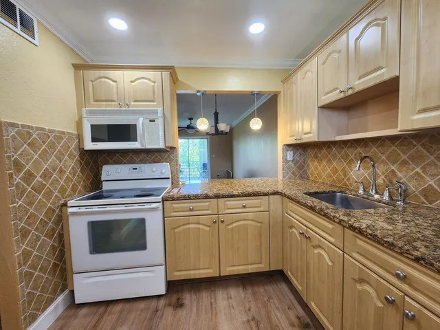 a kitchen with stainless steel appliances granite countertop a stove and a sink