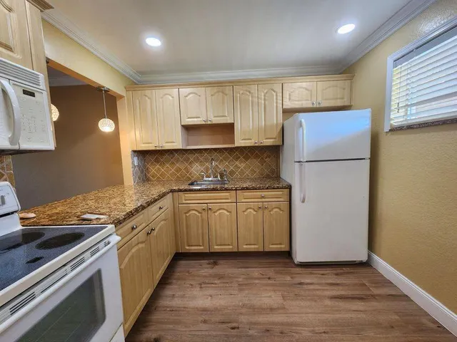 a kitchen with a refrigerator sink and cabinets