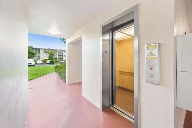 a view of hallway with a door and wooden floor