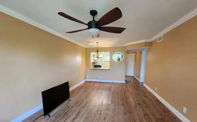 a view of empty room with wooden floor