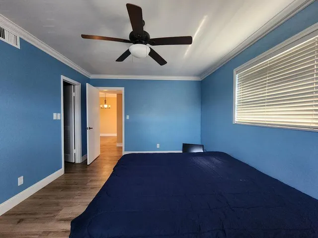 a view of an empty room with window and wooden floor