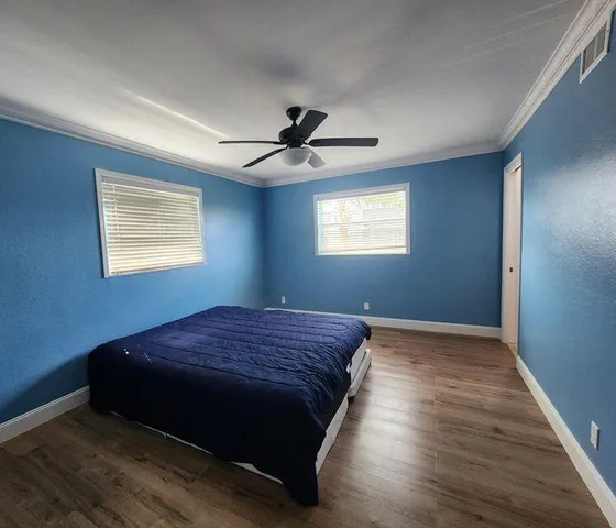 a bed sitting in a bedroom next to a window