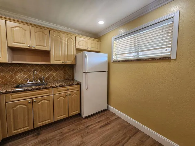 a kitchen with a refrigerator sink and cabinets