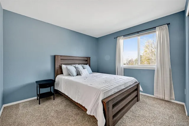 a bed sitting in a bedroom next to a window