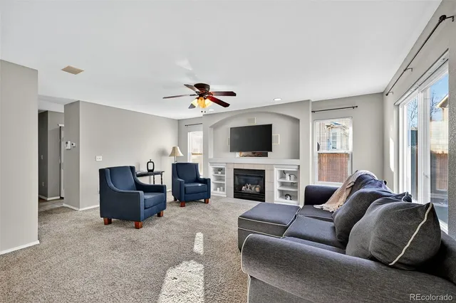 a living room with furniture a fireplace and a flat screen tv