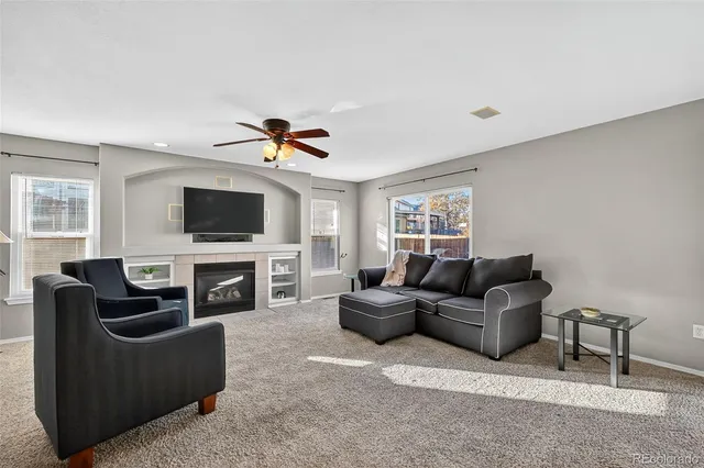 a living room with furniture a flat screen tv and a fireplace