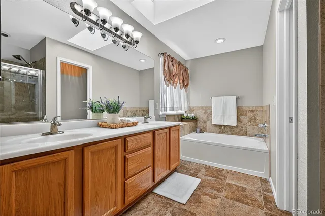 a spacious bathroom with a sink double vanity granite and a mirror