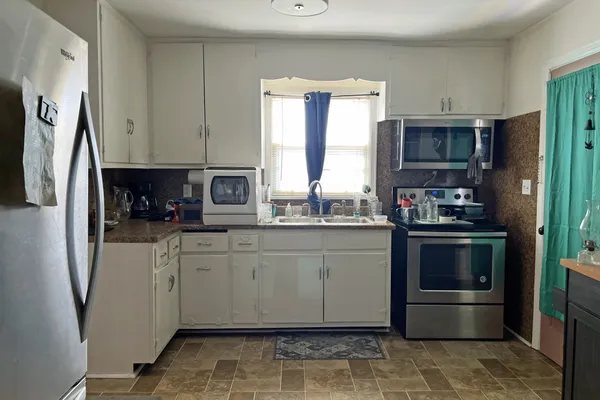 a kitchen with stainless steel appliances a refrigerator sink and microwave