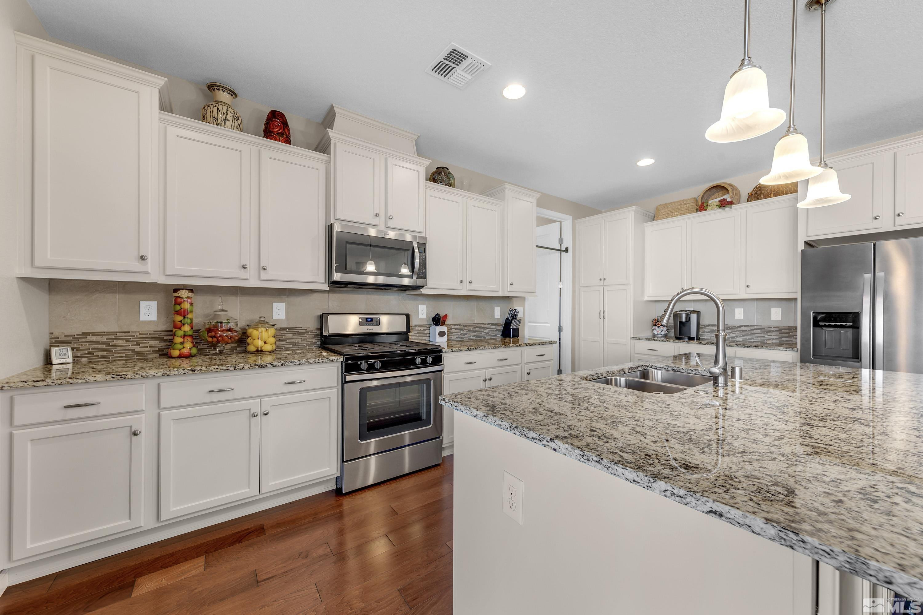 2345 Niatross Lane Reno, NV 89521 - Photo 15 of 40 a kitchen with granite countertop a sink a stove and cabinets