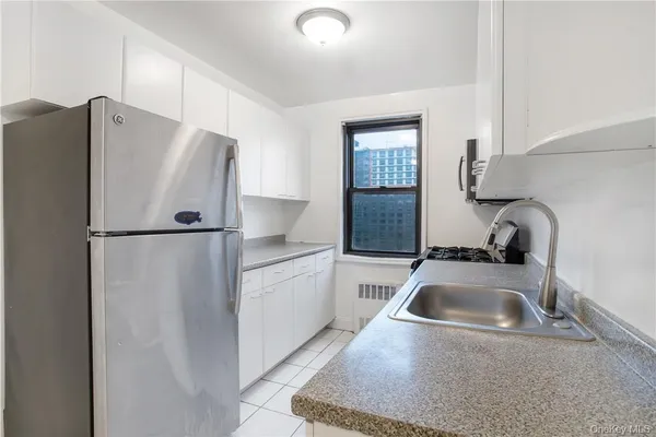 a kitchen with a refrigerator sink and cabinets