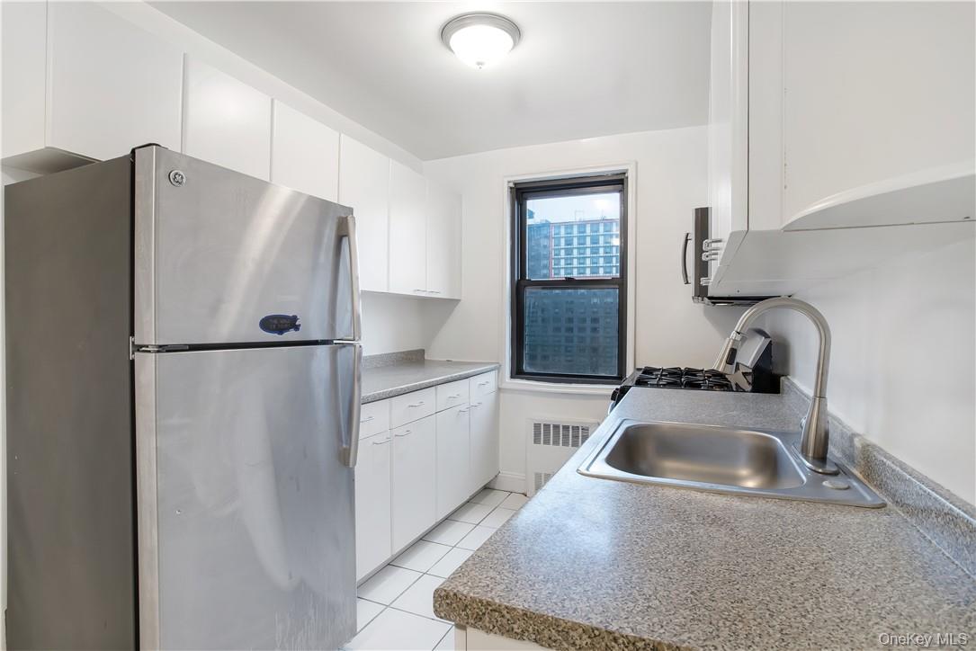 411 Bronx River Road, Unit 7F Yonkers, NY 10704 - Photo 11 of 23 a kitchen with a refrigerator sink and cabinets
