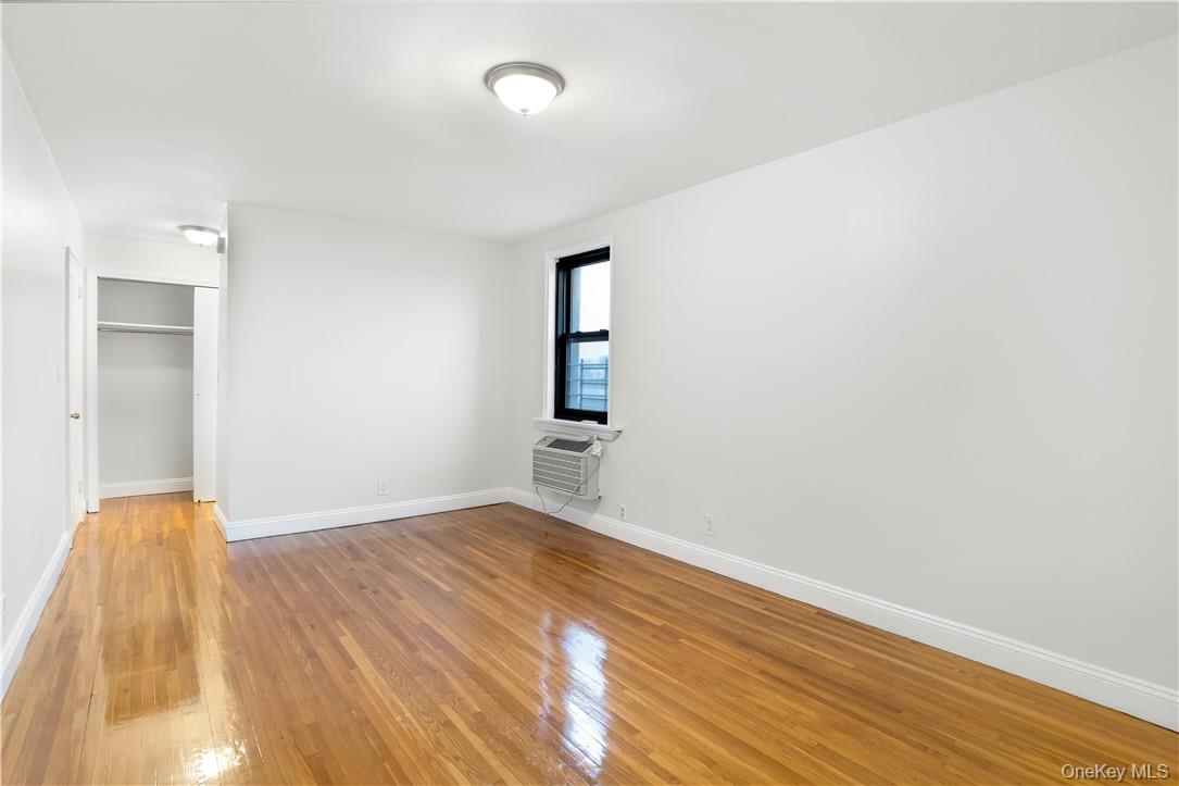 411 Bronx River Road, Unit 7F Yonkers, NY 10704 - Photo 2 of 23 an empty room with wooden floor and windows