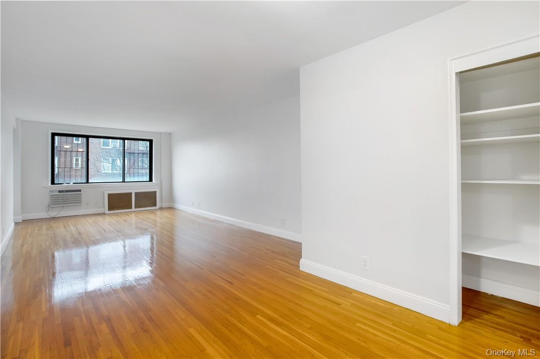 411 Bronx River Road, Unit 7F Yonkers, NY 10704 - Photo 3 of 23 a view of an empty room with wooden floor and a window