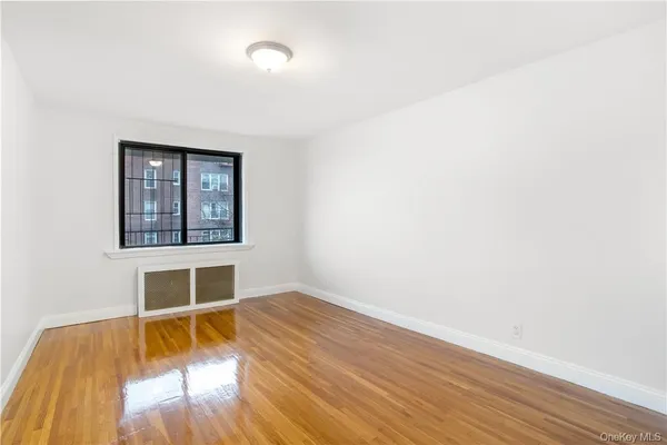 an empty room with wooden floor and a window