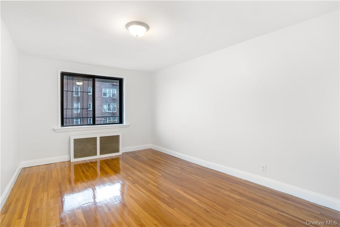 411 Bronx River Road, Unit 7F Yonkers, NY 10704 - Photo 8 of 23 an empty room with wooden floor and a window