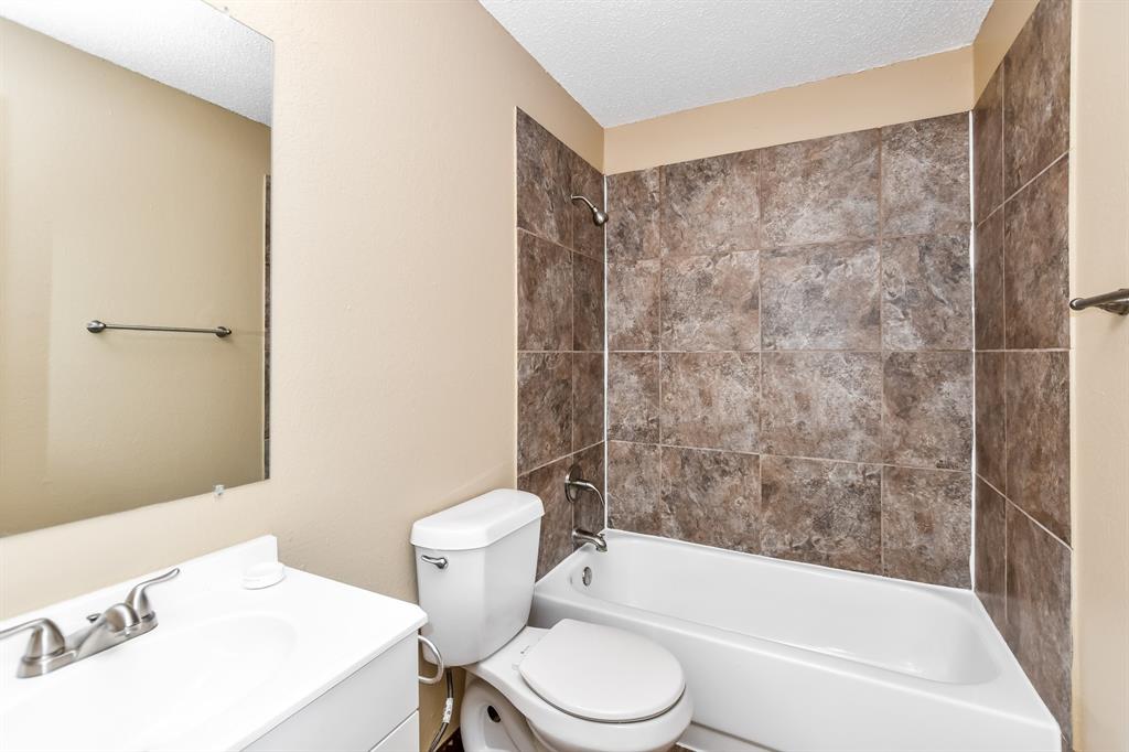 2425 Ithaca Drive Mesquite, TX 75181 - Photo 13 of 17 a bath room with a toilet a sink and a bath tub