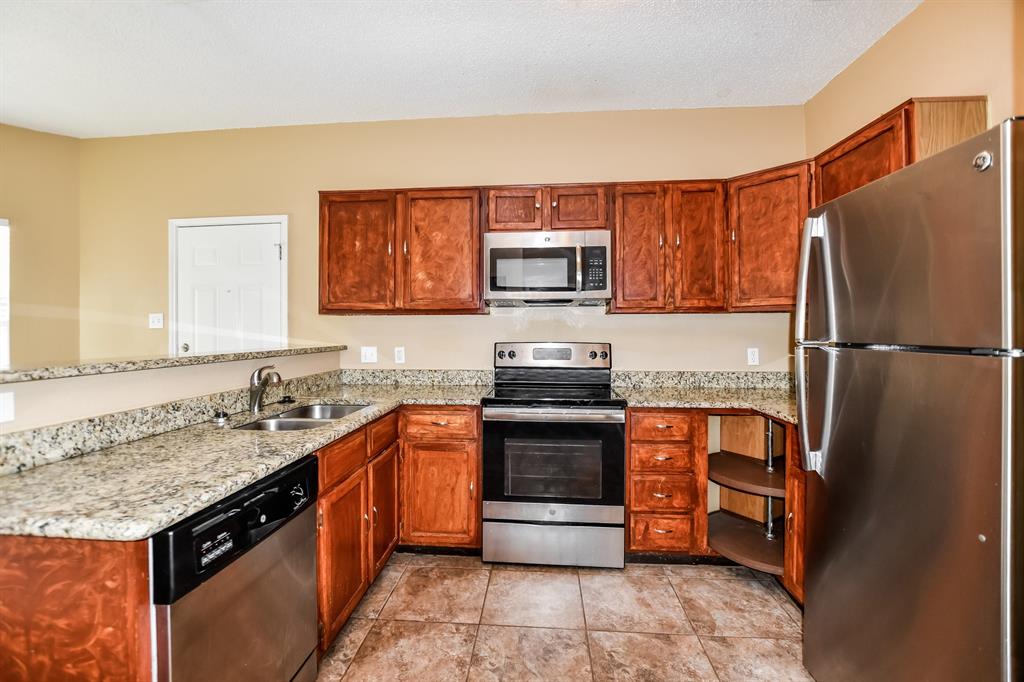 2425 Ithaca Drive Mesquite, TX 75181 - Photo 7 of 17 a kitchen with stainless steel appliances granite countertop a stove a sink dishwasher and a refrigerator