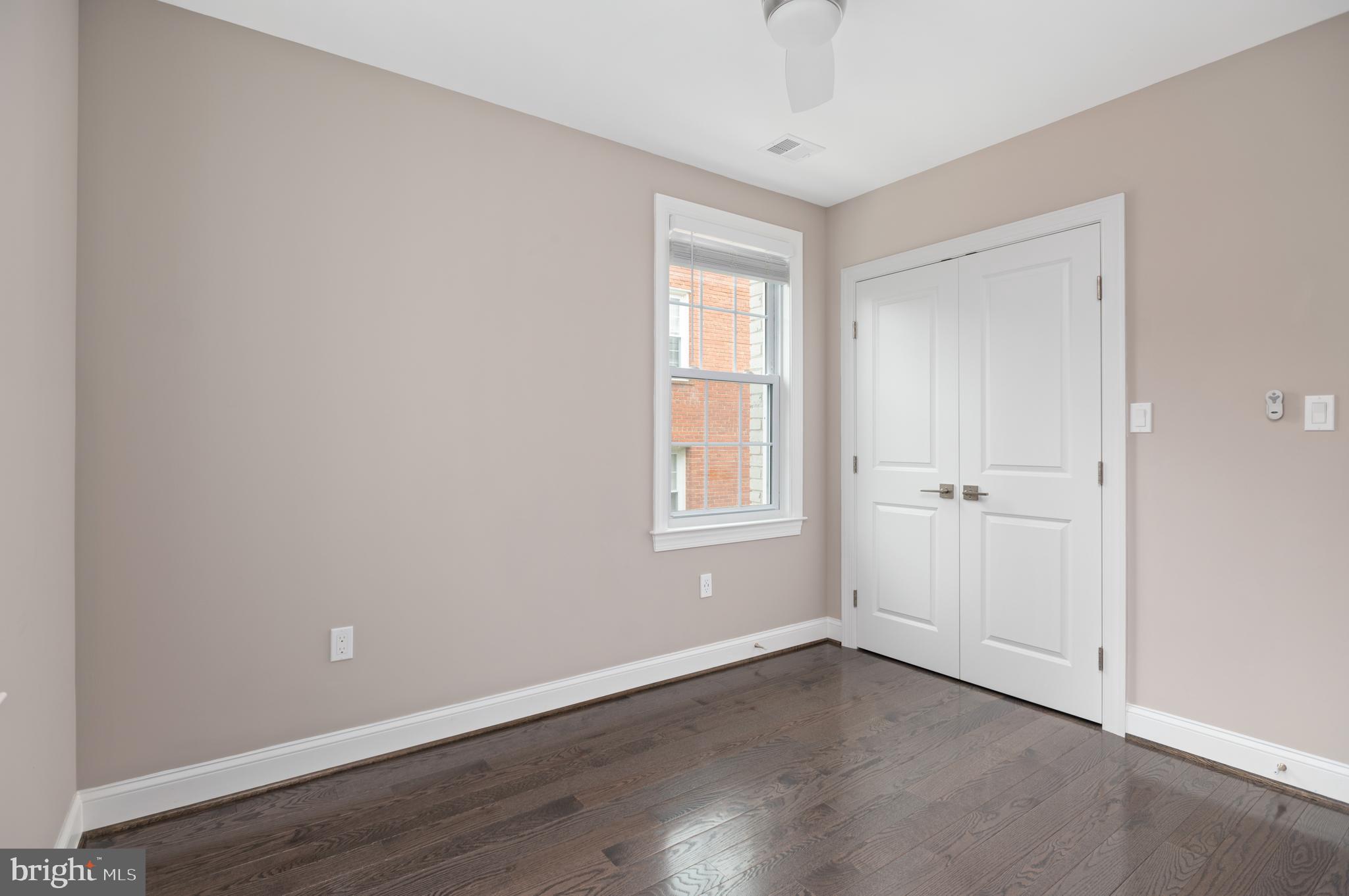 2215 40th Street Northwest, Unit 1 Washington, DC 20007 - Photo 13 of 21 a view of an empty room with wooden floor and a window