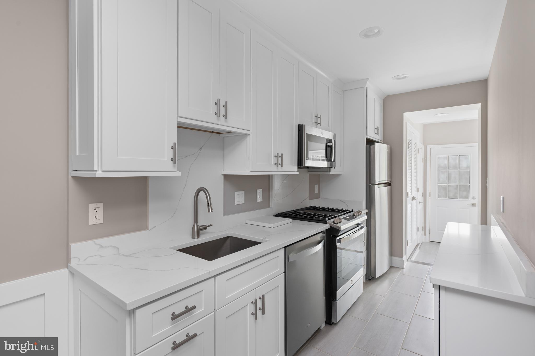 2215 40th Street Northwest, Unit 1 Washington, DC 20007 - Photo 9 of 21 a kitchen with stainless steel appliances granite countertop a sink stove and refrigerator