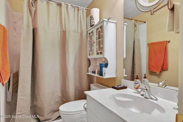 a bathroom with a sink a toilet and shower curtain
