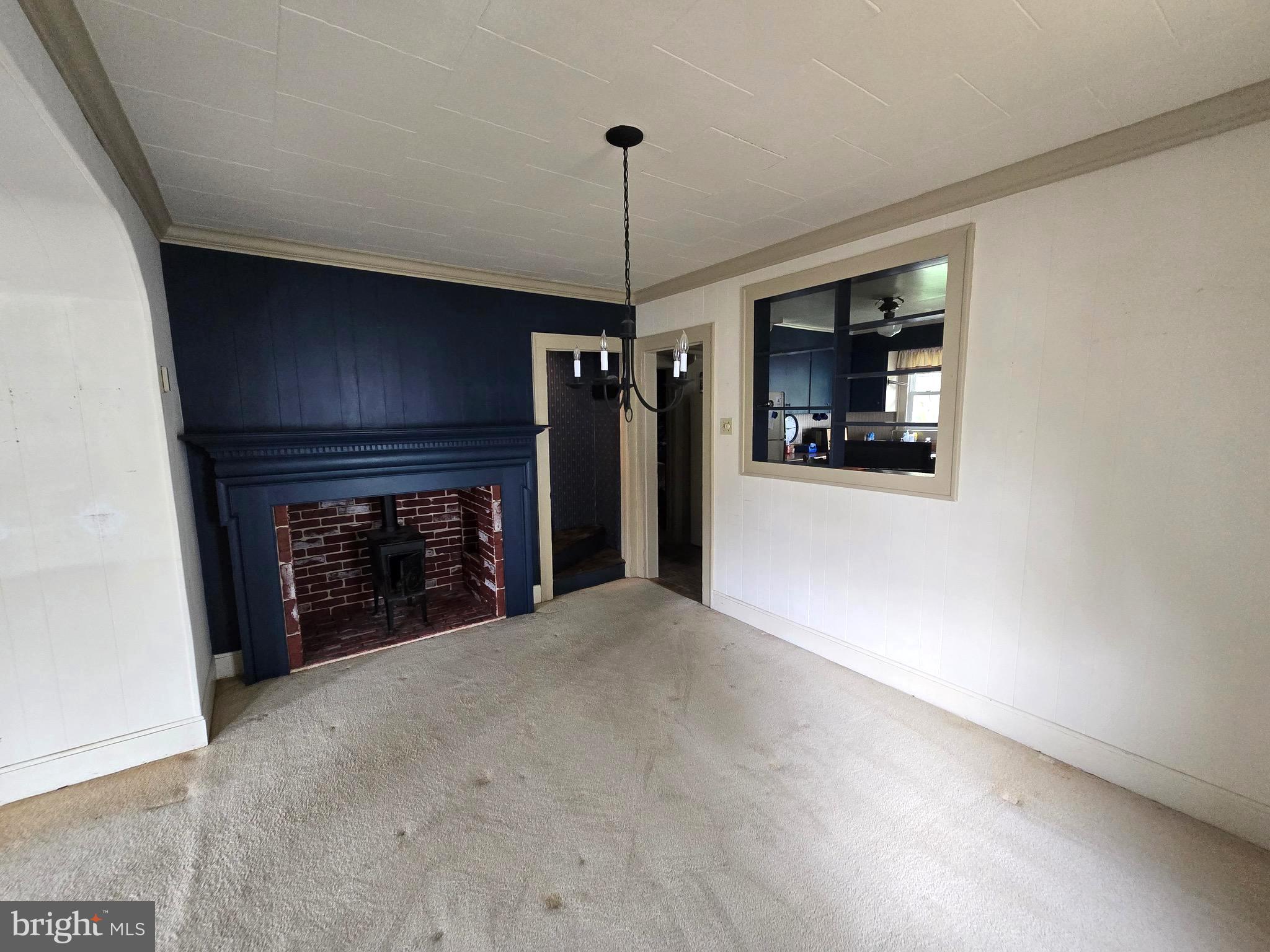26431 Old State Road Crisfield, MD 21817 - Photo 9 of 25 a view of a livingroom with a fireplace and chandelier fan