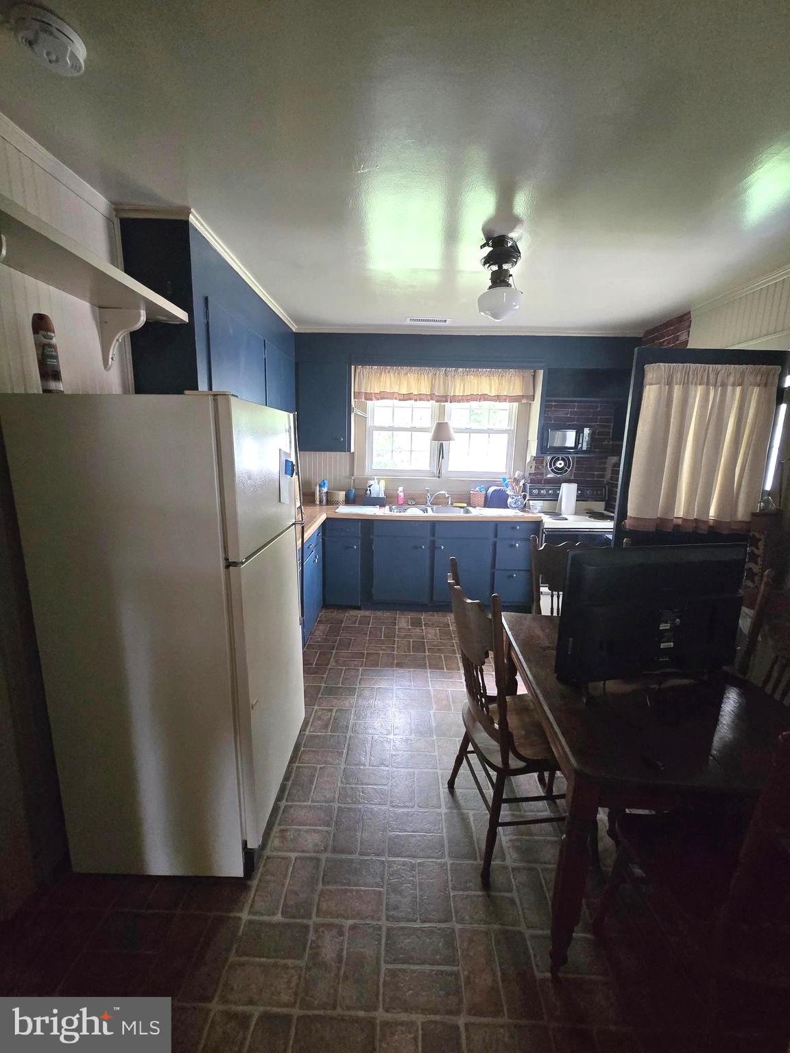 26431 Old State Road Crisfield, MD 21817 - Photo 10 of 25 a kitchen with stainless steel appliances granite countertop a refrigerator a sink a stove a dining table and chairs
