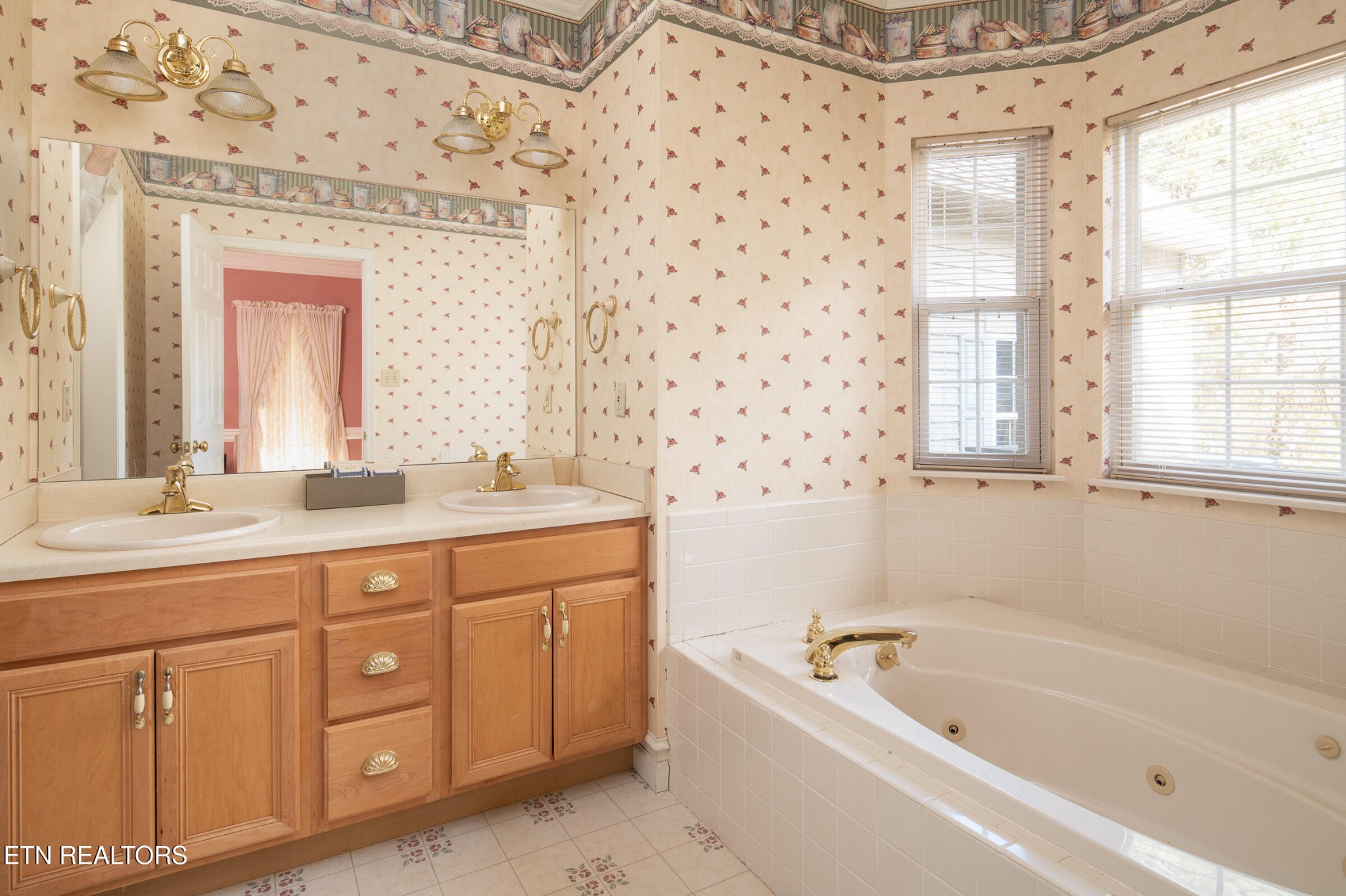 6215 Cardwell Road Corryton, TN 37721 - Photo 18 of 22 a bathroom with a granite countertop sink a large mirror a bathtub and next to a window