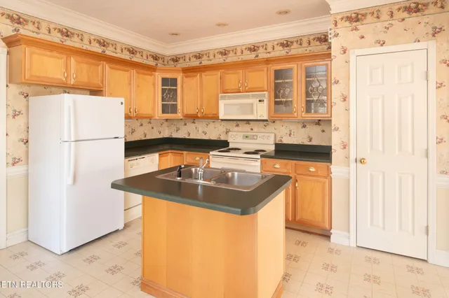 a kitchen with granite countertop a sink stove and cabinets