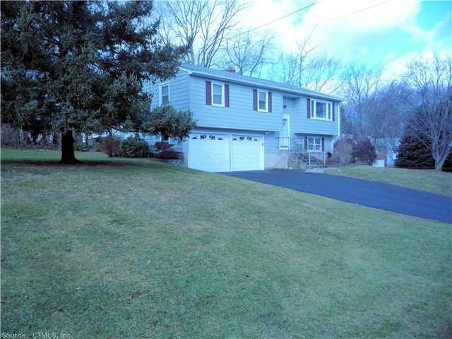 a view of a house with a yard and large trees