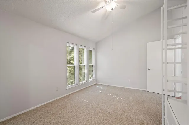 an empty room with chandelier fan