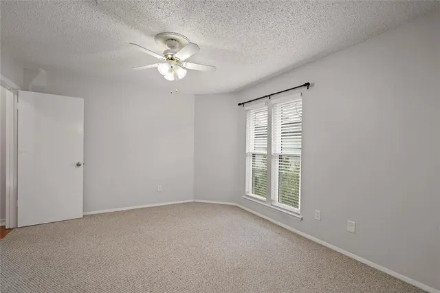 a view of a livingroom with a ceiling fan and window