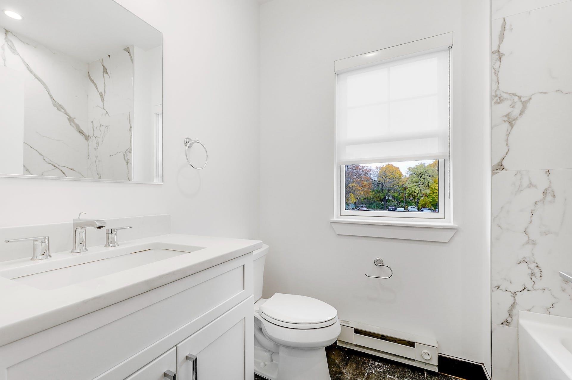 74 Clarendon Place, Unit 202 Hackensack, NJ 07601 - Photo 24 of 33 a bathroom with a sink toilet and a mirror