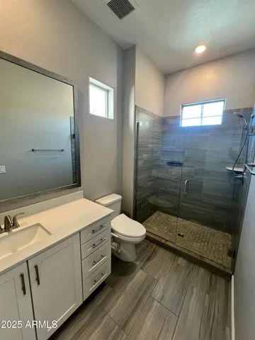 a bathroom with a sink a toilet and shower