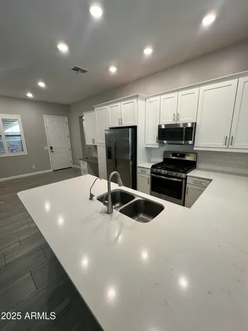 a large kitchen with stainless steel appliances a large counter top