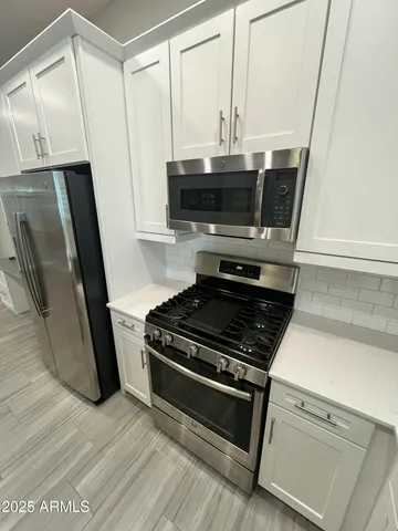 a kitchen with granite countertop a stove and a microwave
