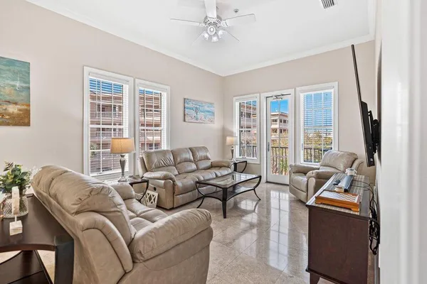 a living room with furniture ceiling fan and a window