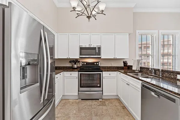 a kitchen with stainless steel appliances granite countertop a stove a refrigerator and a microwave