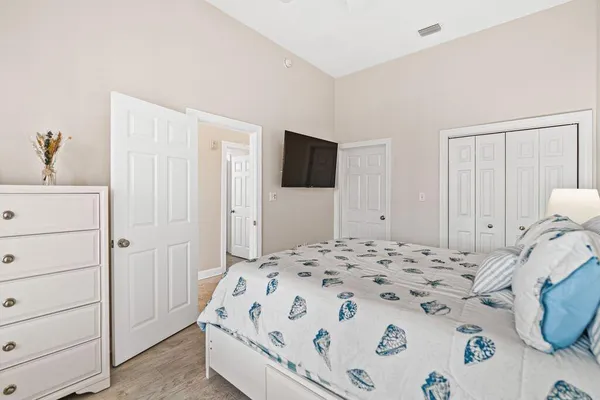 a bedroom with a bed and painting on the wall