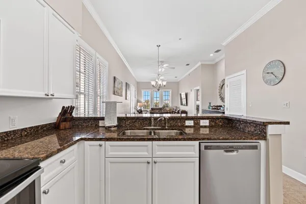 a kitchen with granite countertop a sink a cabinets and window stainless steel appliances