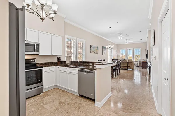 a kitchen with stainless steel appliances granite countertop a refrigerator a sink dishwasher a stove with white cabinets