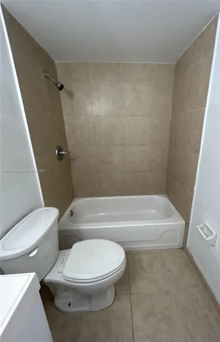 a white toilet and tub sitting next to a bathroom sink