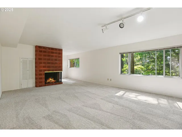 a view of an empty room with a fireplace and a window