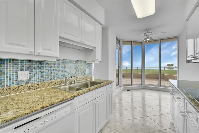 a large kitchen with stainless steel appliances a sink and a large window