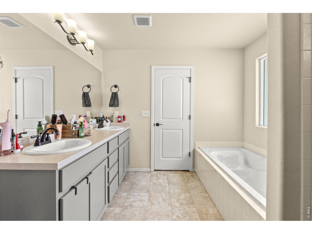 8847 16th St Road Greeley, CO 80634 - Photo 23 of 38 a bathroom with a sink a bathtub a mirror and vanity
