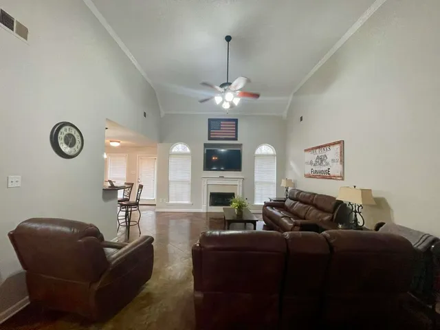 a living room with furniture a fireplace and a chandelier