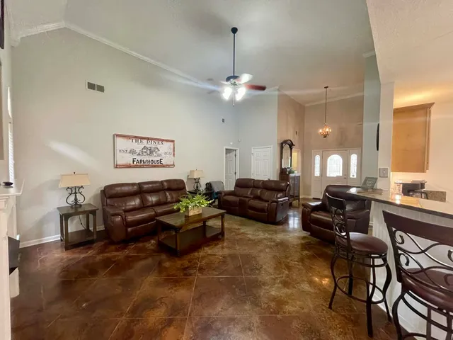 a living room with furniture a chandelier and a window