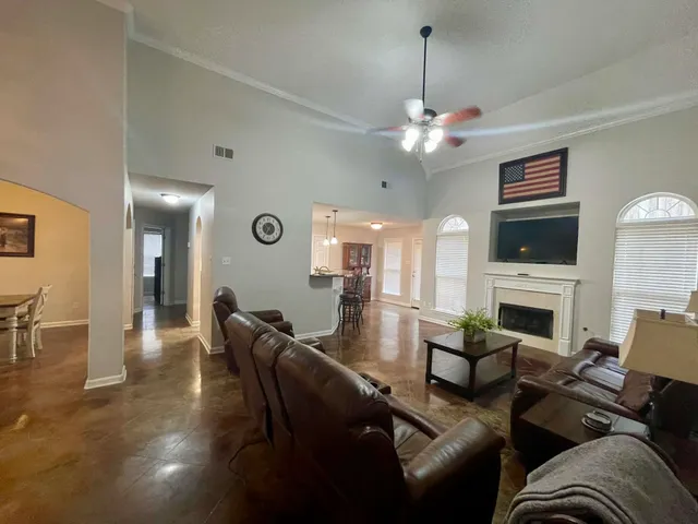 a living room with furniture a fireplace and a chandelier